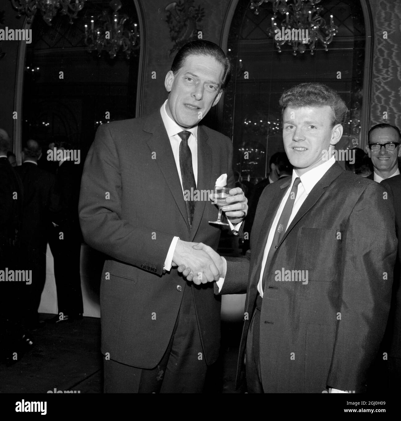 29 Aprile 1965: Cena Football Writer's Associatoin al Cafe Royal. Billy Bremner gioca per la Scozia. Il conte di Harewood, presidente del Leeds United FC, si congratula con Billy Bremner per la sua selezione a giocare per la Scozia. Foto Stock