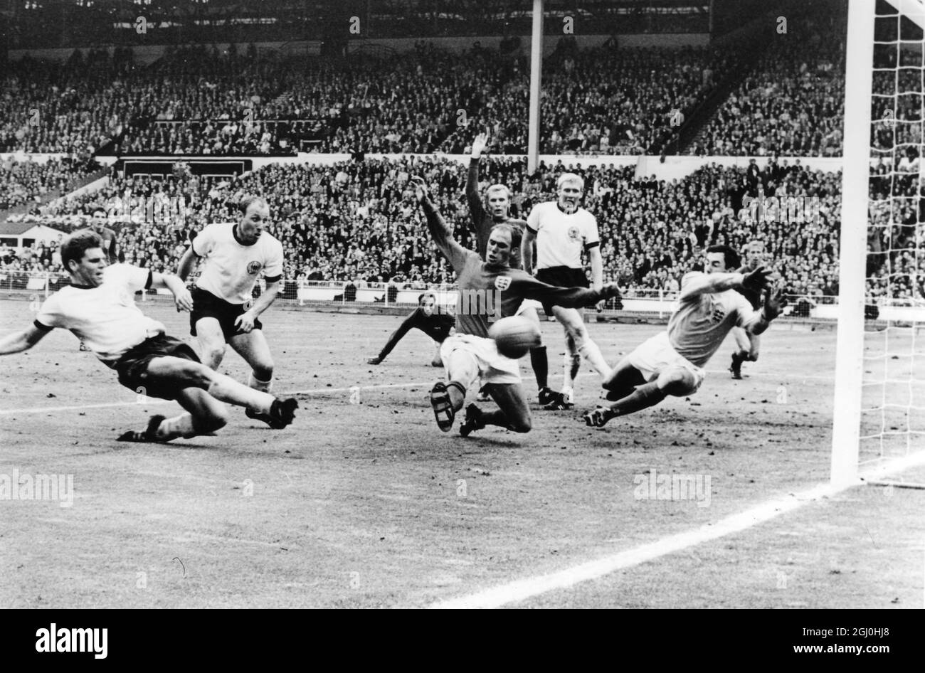 A pochi secondi dalla finale della Coppa del mondo e il lato Wolfgang Weber di West Gemany fa il calcio dopo Gordon Banks in Inghilterra, portiere, per strappare l'eualiserat Wembley Stadium il 30 luglio 1966. Nel tempo extra che seguì, l'Inghilterra segnò due volte per finire con 4-2 vincitori. Anche in questa foto sono il capitano tedesco occidentale Uwe Seeler (seconda a sinistra) Ramon Wilson (camicia scura) d'Inghilterra; dietro Wilson è Moore, il capitano d'Inghilterra; Schnellinger (camicia bianca) e sullo sfondo estrema destra, Jackie Charlton. Appena visto in hte sfondo centro, è George Cohen, l'altro Inghilterra tirare indietro. 30 luglio 1 Foto Stock