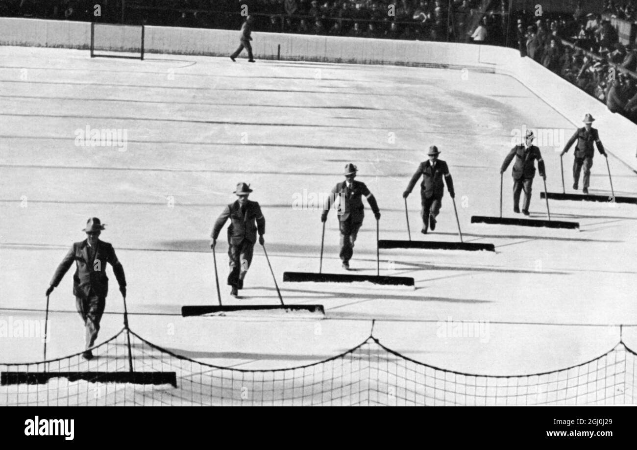 I funzionari passano il ghiaccio sullo stadio di pattinaggio su ghiaccio mentre gli spettatori ascoltano la musica. ©TopFoto Foto Stock