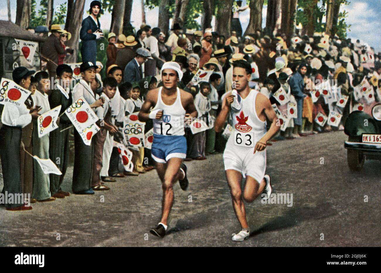 Los Angeles 1932 - vincitrice della maratona Zabala (Argentina) con un corridore canadese e una folla di giovani giapponesi che si stendono lungo la strada. ©TopFoto Foto Stock