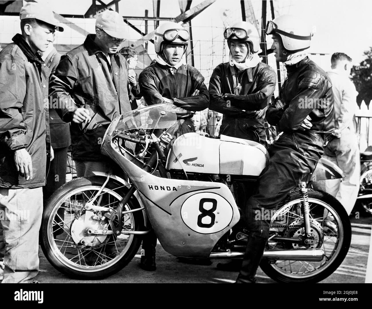 Isle of Man: I membri della squadra giapponese, qui per competere nelle gare TT, chiacchierano con i meccanici dopo la loro prima pratica ufficiale. Stanno guidando le macchine giapponesi Honda, 125cc nelle corse. 27 maggio 1959 Foto Stock