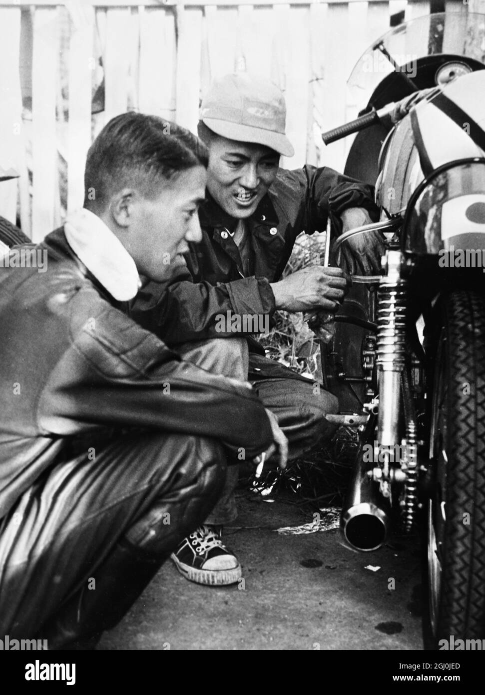 Isola di Man: N Taniguchi, uno dei membri della squadra giapponese di moto qui per le gare TT ha una discussione tecnica con il meccanico capo. Stanno guidando le macchine Honda nelle corse. 27 maggio 1959 Foto Stock