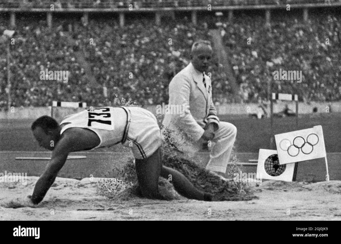 Olimpiadi del 1936, Berlin - questo mostra il salto di 8,06 metri con cui Jesse Owens ha rotto il record olimpico e mondiale. I due flag sulla destra indicano due contrassegni di registrazione precedenti. (Das war der sprung von 8,06 Meter, mit dem Jesse Owens den olympischen und den Weltrekord uberbot. Die beiden Fahnchen rechts im Bilde zeigen die beiden ubersprungen Rekordmarken an.) ©TopFoto Foto Stock