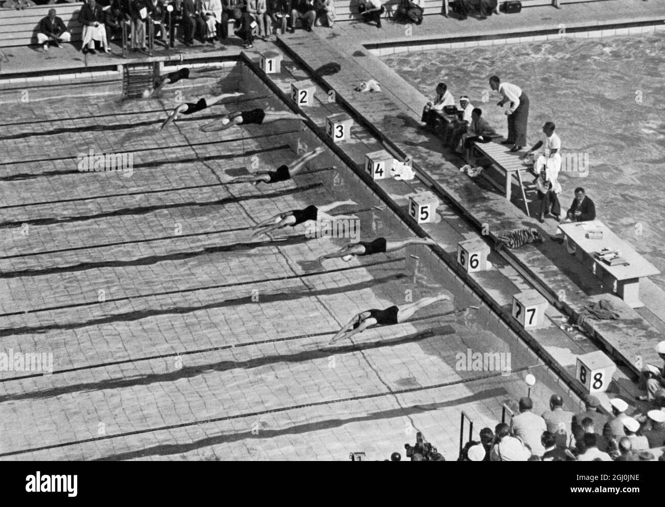 Olimpiadi del 1936, Berlino - un meraviglioso inizio della lotta finale del nuoto freestyle femminile di 100 m. Ria Mastenbroek (medaglia d'oro per i Paesi Bassi) è primo del blocco (corsia n. 5). (Ein wunderbares Startbid vom Endkampf der Frauen im 100 m Freistillschwimmen. Vom Vlock Nr. 5 startet Ria Mastenbroek.) ©TopFoto Foto Stock