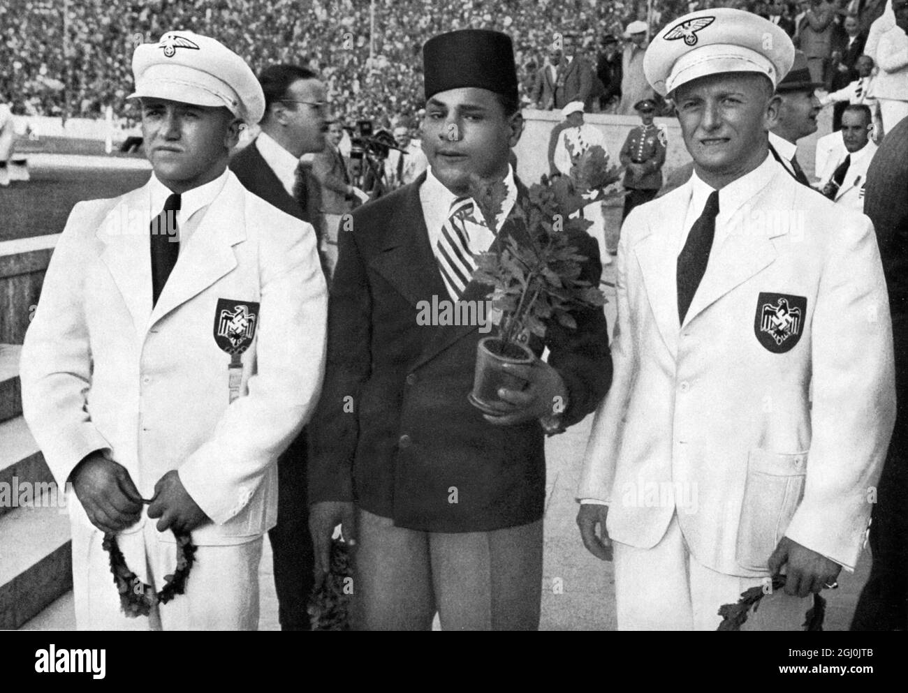 Olimpiadi del 1936, Berlino - Weightlifter vincitori: 1. Touni-Egitto (centro), 2. Ismayr-Germania (a destra), e 3. Wagner-Germania (a sinistra). (Siegerehrung fur das Gewichtheben: 1. Touni-Agypton (mitte), 2. Ismayr-Deutschland (Rechts). 3. Wagner-Deutschland (Links).) ©TopFoto Foto Stock
