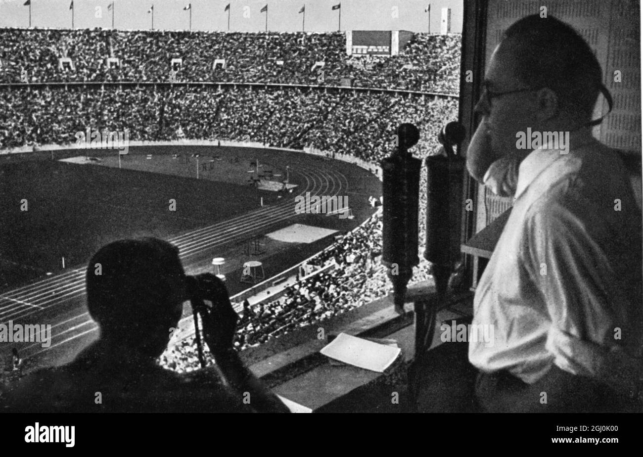 Olimpiadi del 1936, Berlino - l'emittente nel suo stand, alto sopra lo stadio pieno di circa centomila spettatori. (Der Rundfunksprecher in seiner Zelle, hoch oben uber dem Stadionrund, das gefelt ist mit Hunderttausend.) ©TopFoto *** Local Caption *** l'altoparlante di trasmissione nella sua cella, più alto di circa lo stadio, è gefullt con centomila. Foto Stock