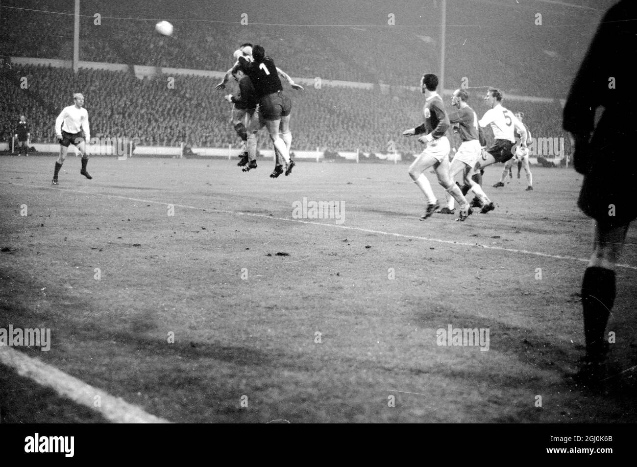 Wembley, Middlesex: Inghilterra e Leeds United player Jackie Charlton; (metà centro). Il portiere della Germania occidentale Hans Tilkowski è raffigurato in azione durante il Football Association International Match presso l'Empire Pool tra Germania e Inghilterra stasera. La partita è stata disputata in condizioni di pioggia intensa, in condizioni di nebbia; è stata seguita da una folla stimata a 50,000. 23 febbraio 1966 Foto Stock