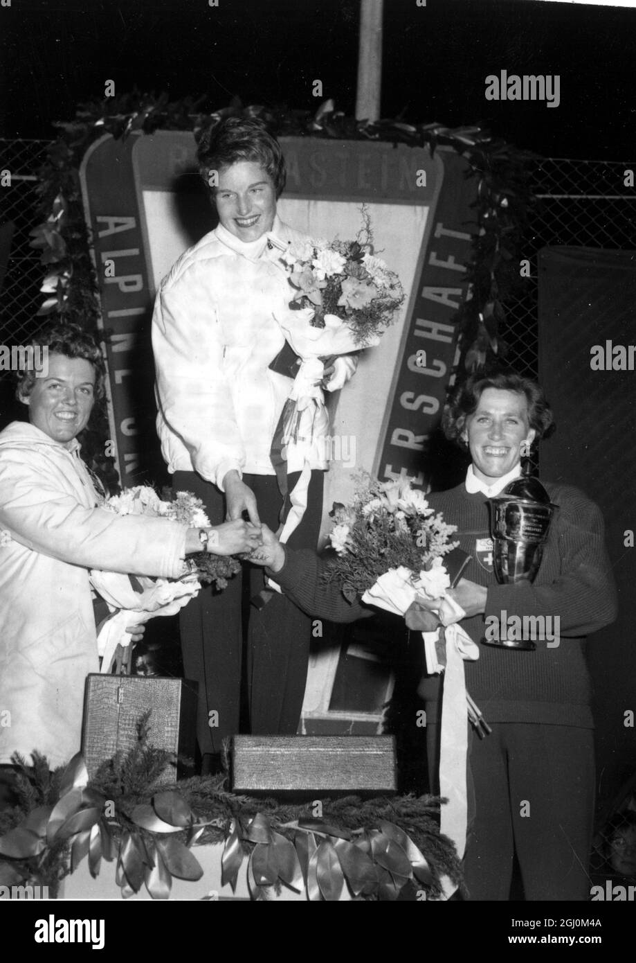 Lucille Wheeler del Canada al centro si aggrappa con i secondi classificati dopo la premiazione per il Ladies Giant Slalom a Bad Gastein. Sulla sinistra si trova Sally Deaver degli Stati Uniti 2 ° e Frieda Daenzer d'Austria. 11 febbraio 1958 Foto Stock