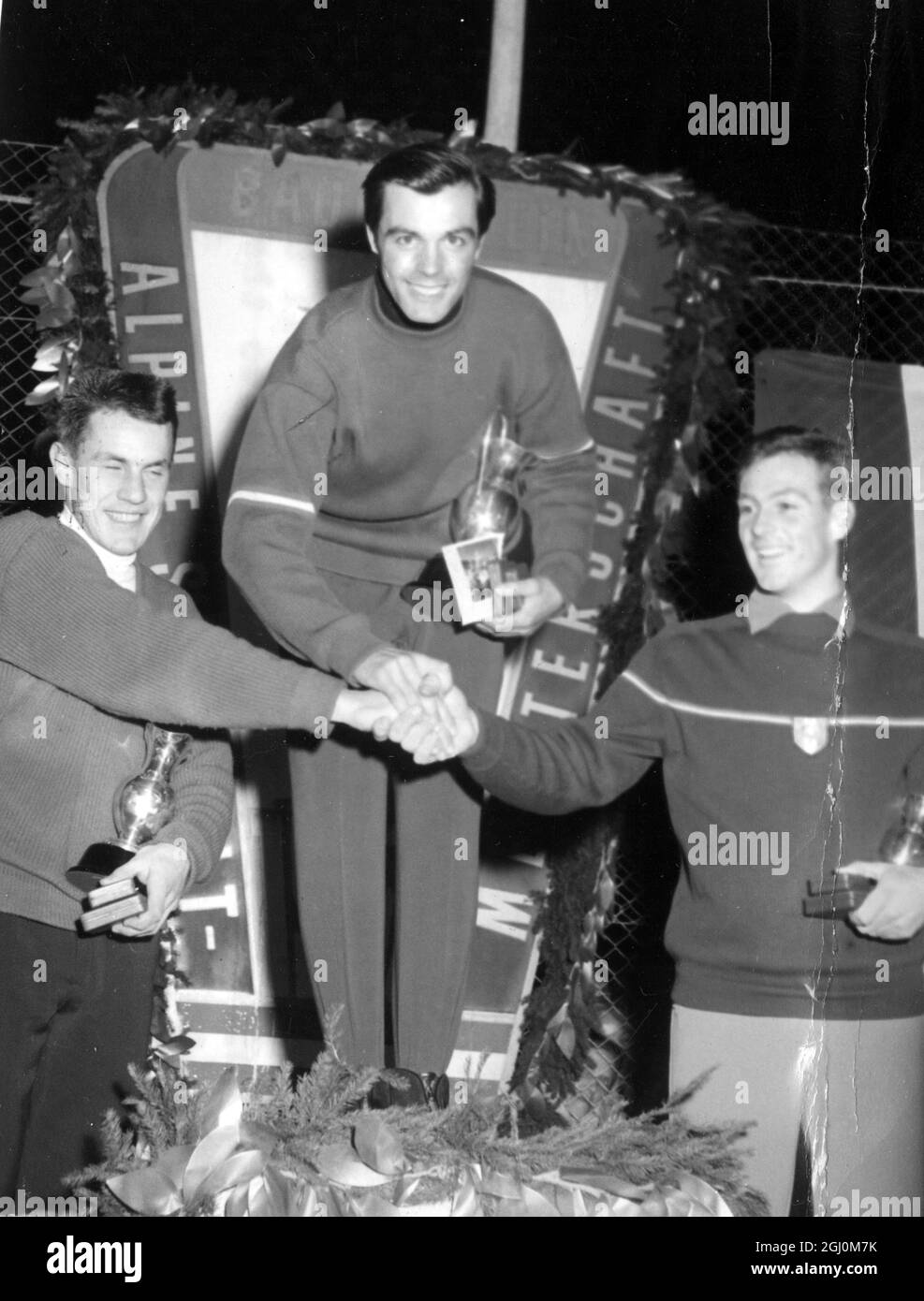 Tony Sailer d'Austria scrolla le mani con i secondi classificati della Svizzera Roger Staub a sinistra e Jean Vuarnet di Francia dopo i Campionati mondiali di sci alpino del 11 febbraio 1958 Foto Stock
