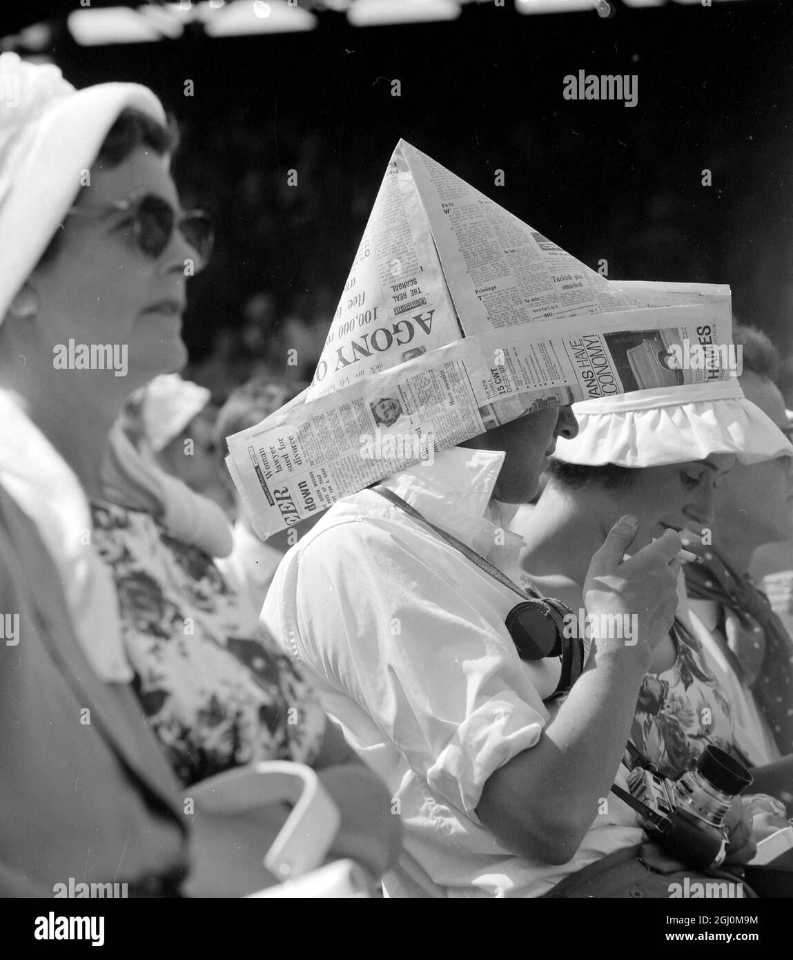 Wimbledon Gent combattendo il caldo sfrigolante estivo e la sua signora in un cofano bianco frillato erano entrambi a guardare il gioco. 30 giugno 1961 Foto Stock