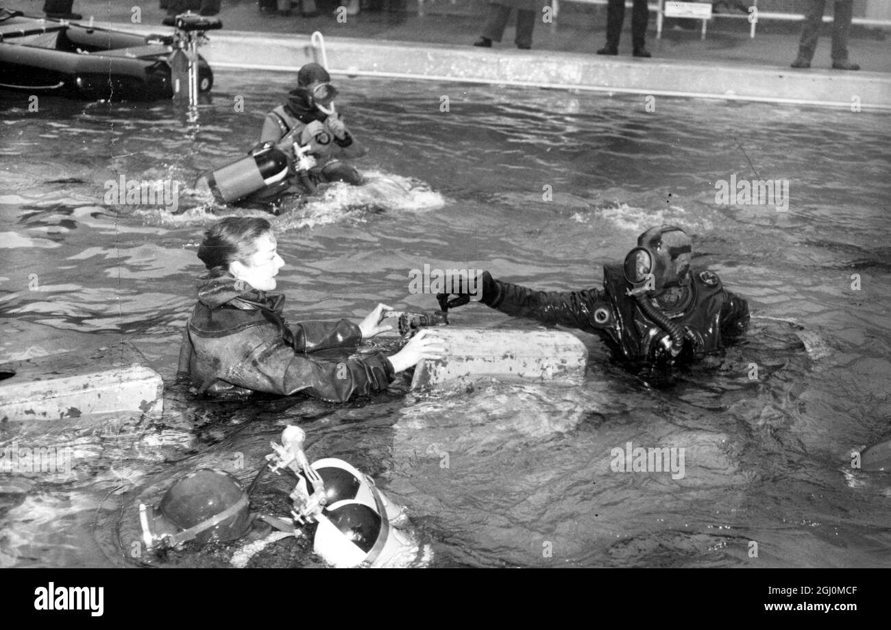 London England Exhibition Underwater Equipment British Sub Aqua Club nuoto attorno al sottomarino due uomini . 25 marzo 1958 Foto Stock