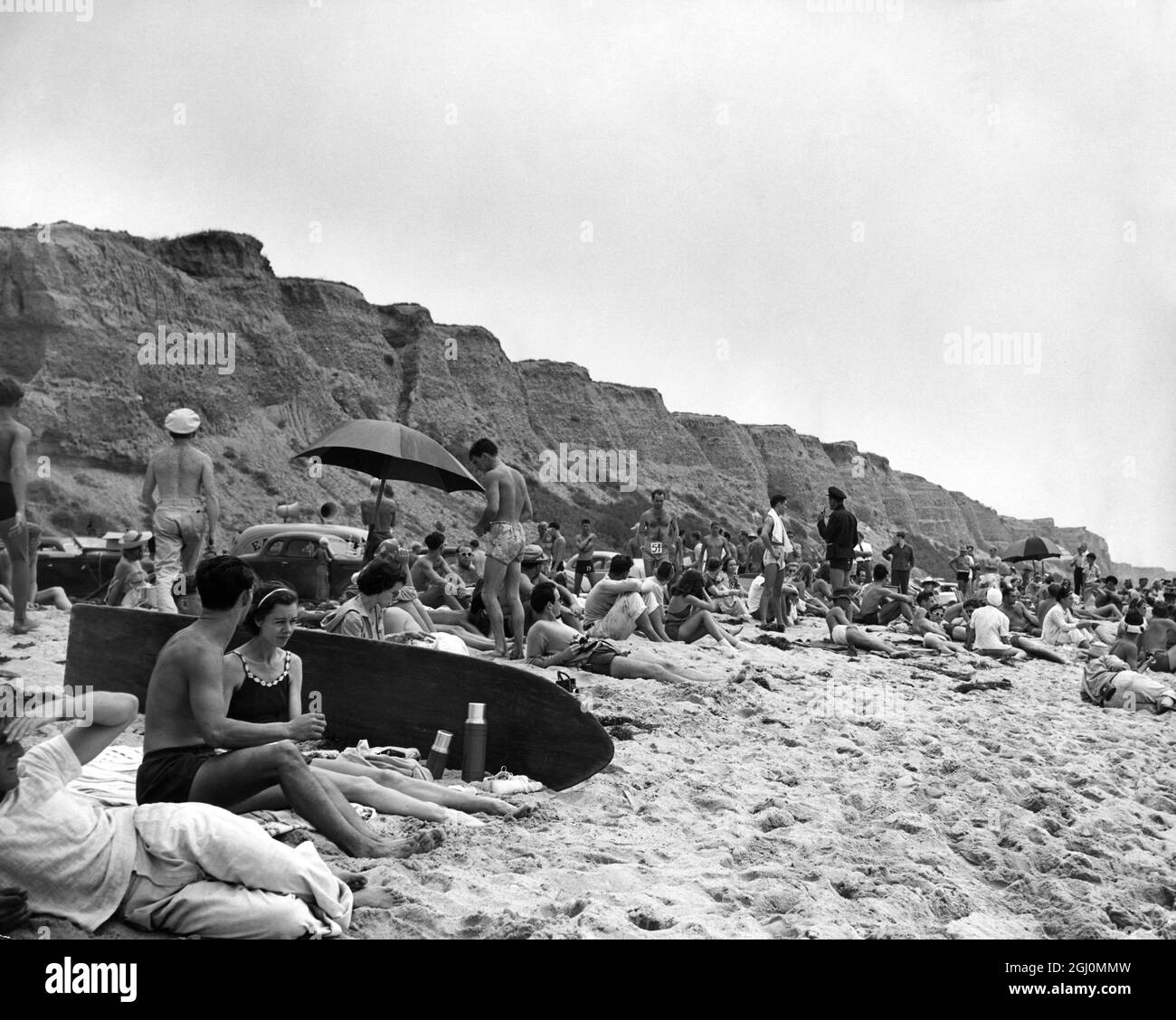 Cavalcando la cresta di un'onda ondulata , salito lungo la tavola lucida e sfrecciando prima del surf ampio è lo sport maestoso degli antichi Re Hawaiiani e uno che ha catturato l'immaginazione di un culto in rapida crescita dei surfisti fanatici . Viaggiando per miglia alle spiagge bianche della California del Sud ( queste foto sono state scattate alla spiaggia remota di San Orofre circa venti miglia a sud di Laguna Beach , sull'autostrada per San Diego ) , gli uomini e le donne , di solito lithe , magre e splendidamente formate , versare in auto e carrelli , rendere la spiaggia la loro casa per il fine settimana , dimenticare il tamburo di falce Foto Stock