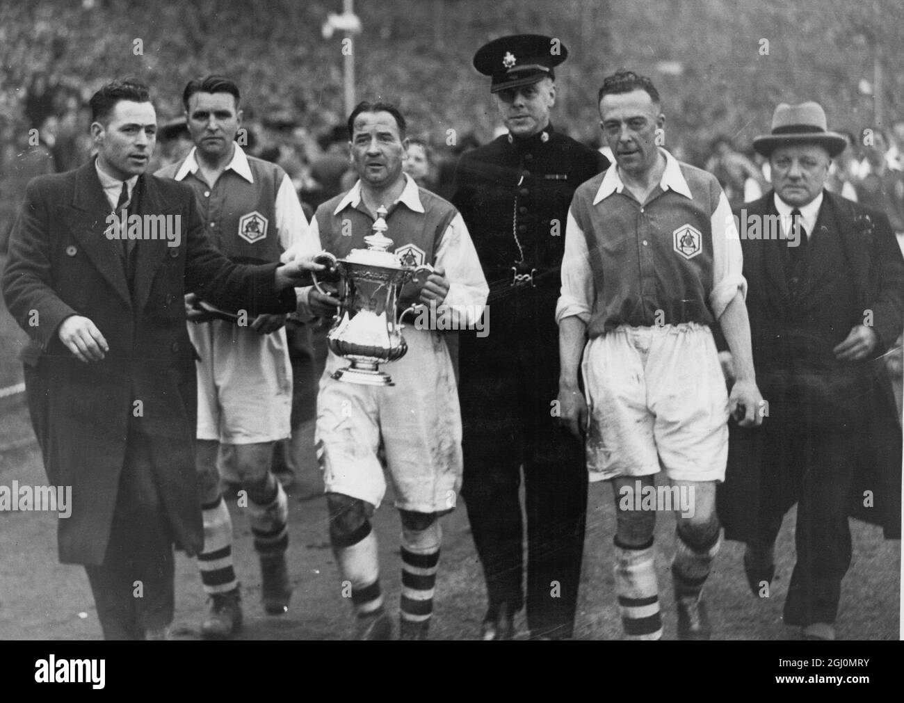 La squadra dell'Arsenal dopo aver vinto la finale della fa Cup 1936 contro Sheffield United al Wembley Stadium , Londra , Inghilterra . Alex James porta la tazza . 25 aprile 1936 Foto Stock