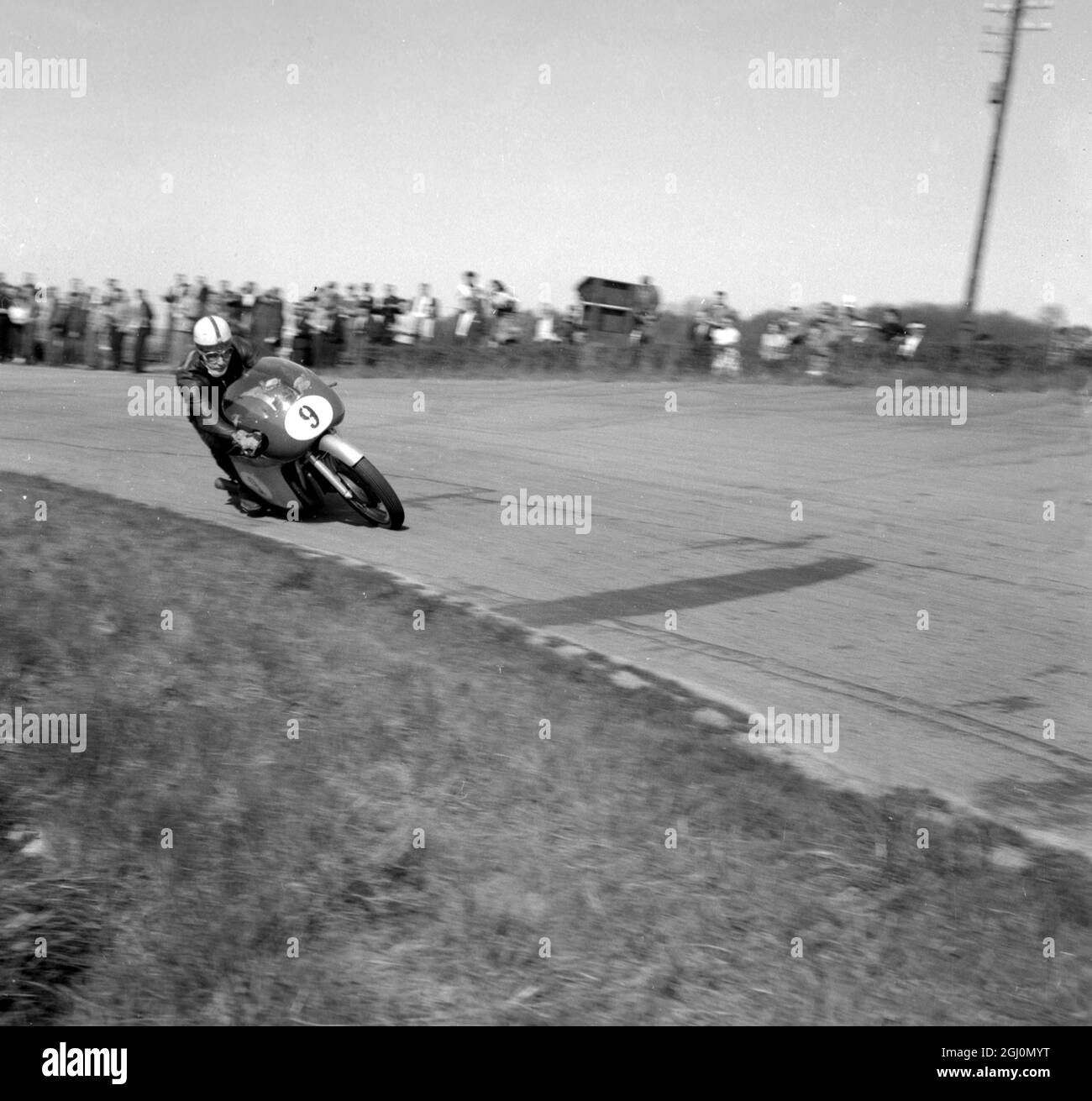 Mettet , Belgio : il famoso John Surtees britannico che guida la sua MV Augusta all' Internation Motor Cycling Meet . Surtees ha vinto l'evento 350 cc ad una velocità media di 90 mph e l'evento 500cc a 95 . 8 mph . David Chadwick ( Norton ) , fu secondo nel 350 e terzo nel 500 . 6 maggio 1958 Foto Stock