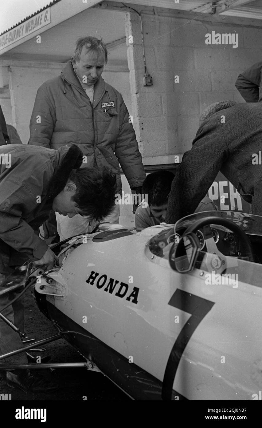 Meccanici giapponesi che lavorano sulla sospensione della vettura John Surtees Honda durante i test a Brands Hatch 1967 Foto Stock