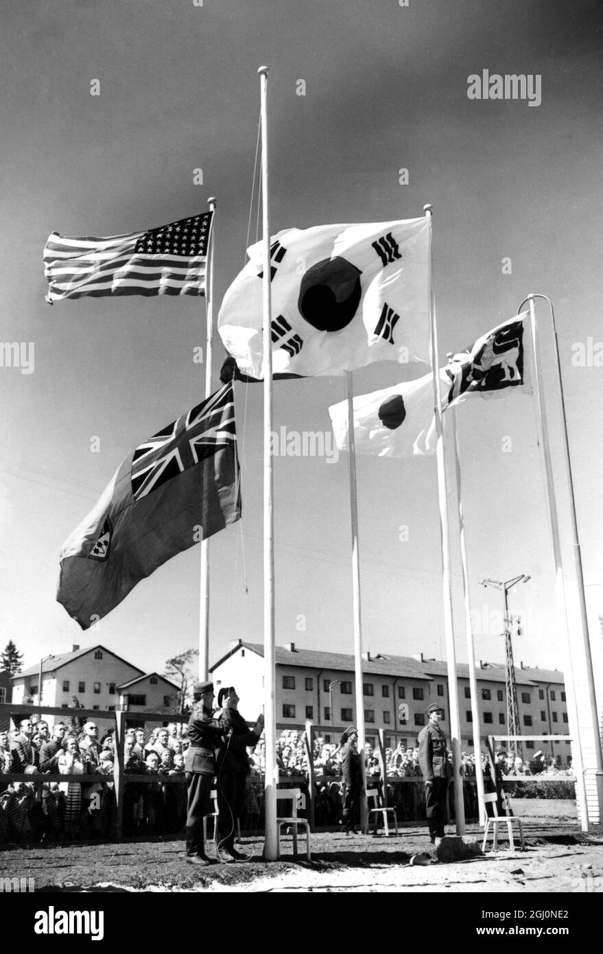 Helsinki : i soldati finlandesi alzano la bandiera canadese ai principali alberi durante la bandiera - cerimonia di sollevamento al villaggio olimpico appena formato a Helsinki . 9 luglio 1952 Foto Stock