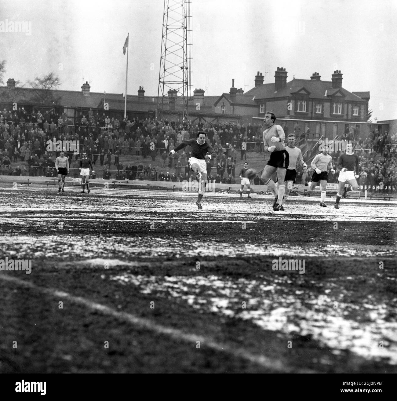 Nella foto durante la partita di terza manche della fa Cup ci sono n. 7 Rotherham fuori-destra Kirkman (sinistra) spara al Watford Goal come giocatore di Watford (3°) sembra che stia facendo l'ultima danza ''loop-de-loo''' con un partner invisibile. 20 febbraio 1963 Foto Stock