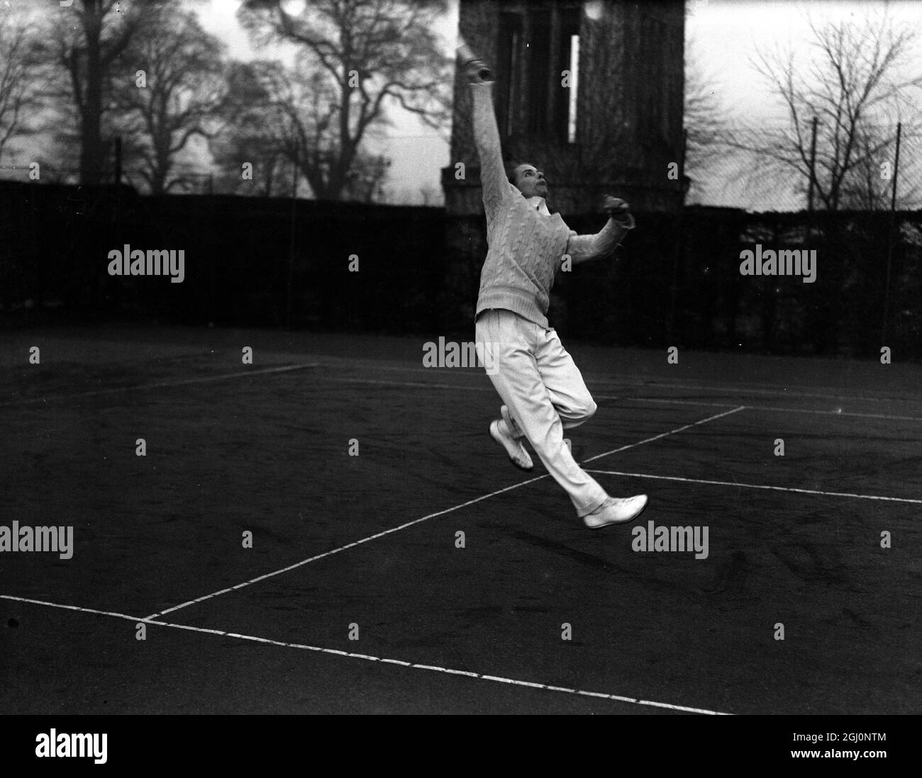Bunny Austin di Gran Bretagna , la famosa stella del tennis in addestramento intenso per le prossime partite della Coppa Davis a Wimbledon , Inghilterra . Visto qui praticare il suo colpo di testa . 8 febbraio 1935 Foto Stock