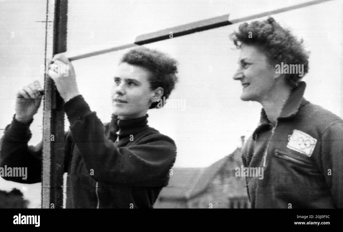 Controllo del salto alto . Melbourne , Australia ; Woman High Jumpers , Inge Kilian ( a sinistra ) della Germania e Dorothy Tyler della Gran Bretagna , aggiustano l'High Jump Bar sulla pista dell'Università di Melbourne dove stanno facendo il loro addestramento oggi in preparazione ai Giochi Olimpici . 17 novembre 1956 Foto Stock