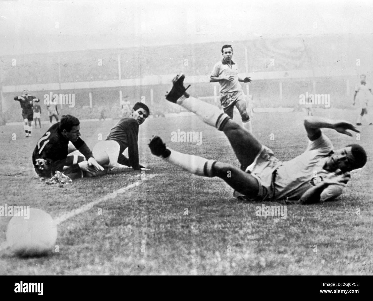 Goalie ungherese in azione . Liverpool , Inghilterra : il portiere ungherese , Josef Gelei , è raffigurato con Kalman Miszoly , mentre la palla va oltre la linea durante la loro partita di Coppa del mondo , con Jair del Brasile ( a destra ) in cerca . L'Ungheria batte il Brasile 3 - 1 . 15 luglio 1966 Foto Stock