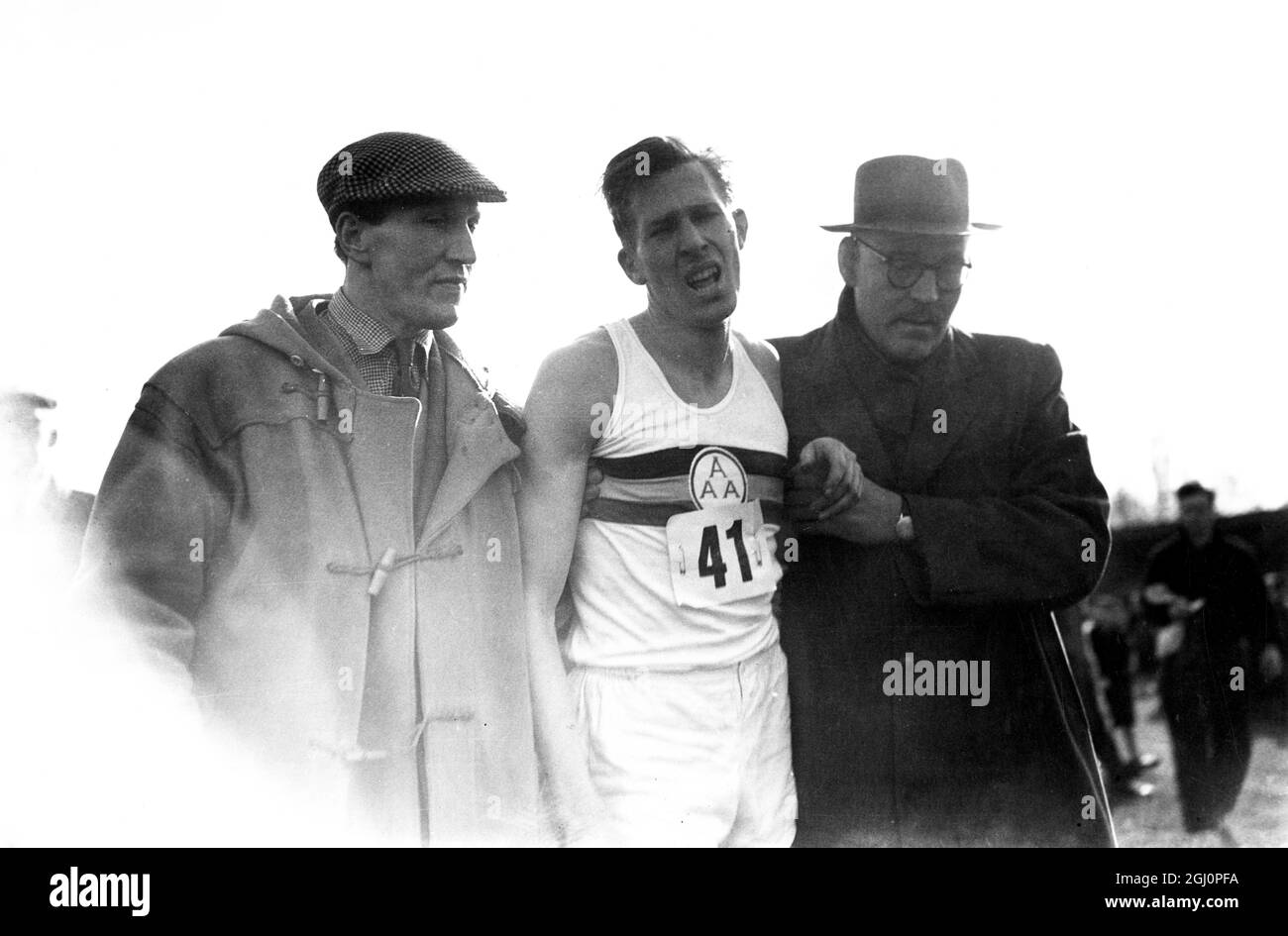 Roger Banister rompe il record mondiale Mile Roger Banister viene dato una mano da Franz Stampel e un altro alla fine del suo record importante Mile a Oxford Banister's tempo era di 3 minuti 59.4 secondi. 6 maggio 1954 Foto Stock