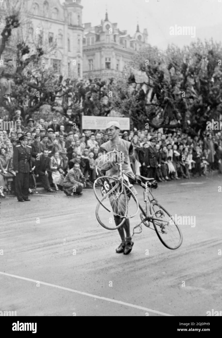 Karlovy Vary , Cecoslovacchia : Willy Funke della Repubblica Federale tedesca , prende la sua moto e si mette a camminare dopo una pesante caduta verso la fine della nona tappa della annuale gara ciclistica di Varsavia - Berlino - Praga . Questa fase è stata vinta da va't Hof dell'Olanda. 14 maggio 1956 Foto Stock