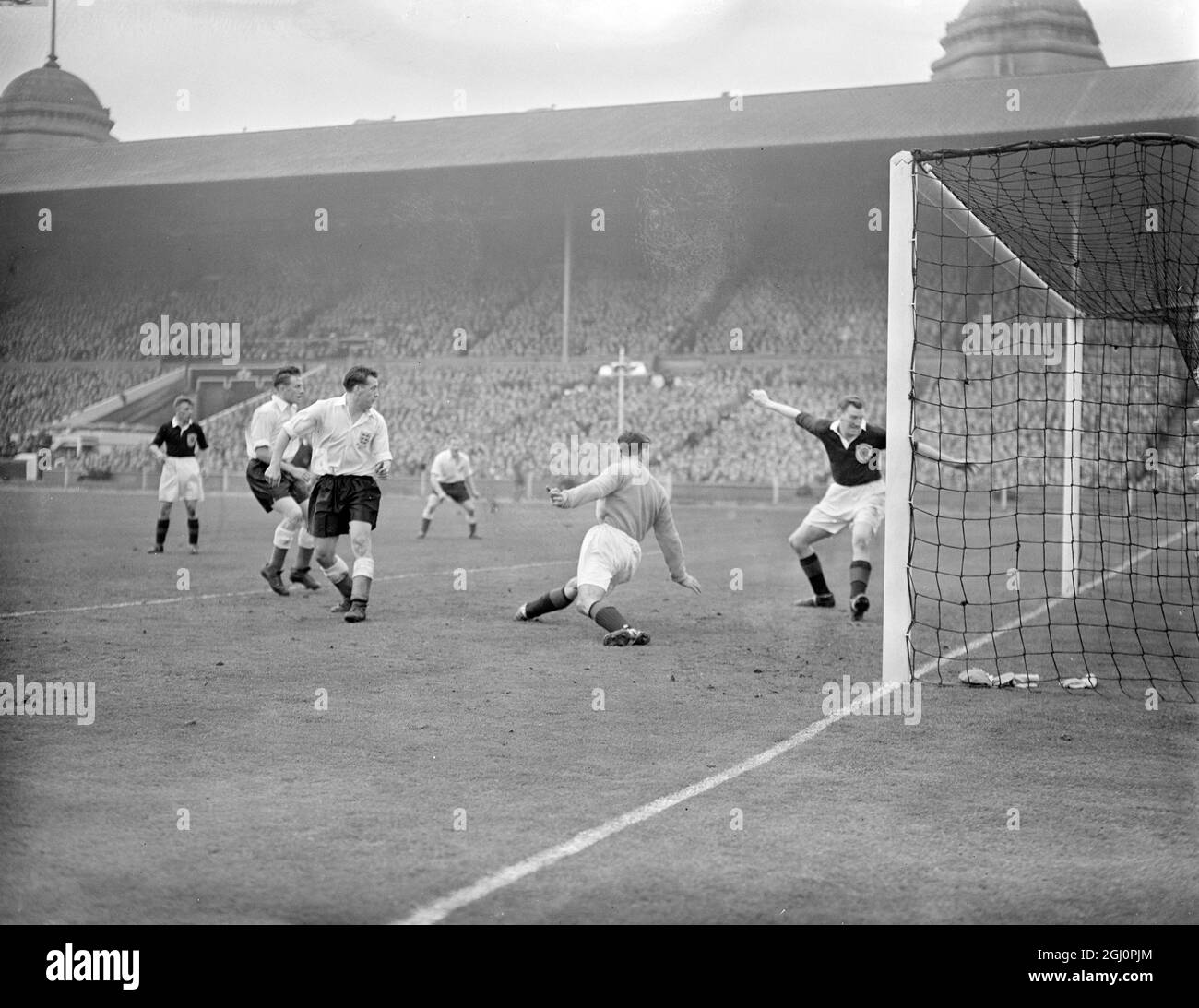 Il secondo obiettivo di Enbgland a Wembley è internazionale contro la Scozia. All'interno-destra Ivor Broadis ha segnato , nonostante gli sforzi del portiere Farm e Young ( Capitano) , indossando una camicia scura . A sinistra ci sono Redfern, Froggatt e Lofthouse , entrambi in Inghilterra . La partita è stata un pareggio 2-2 . 18 aprile 1953 Foto Stock