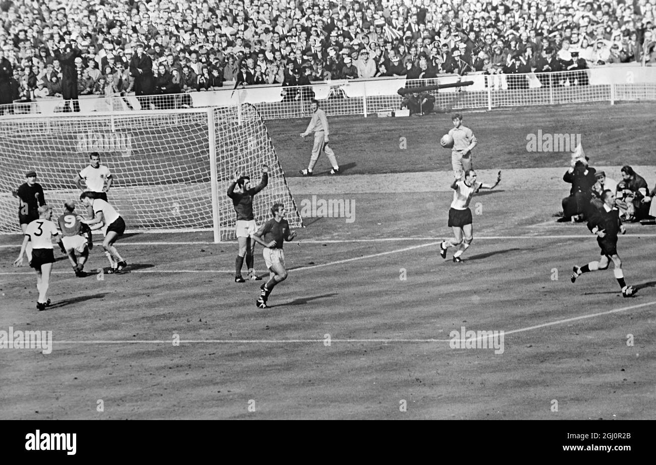 Terzo obiettivo controverso. Wembley, Inghilterra : arbitro svizzero, Gottfried Dienst (a destra ) si esaurisce per consultare il lineman russo come Bobby Charlton inglese ( no. 9 ) prova a dimostrare ai giocatori tedeschi che il colpo di Geoff Hurst era un obiettivo. Hurst ( armi sollevate ) guarda ansiosamente mentre il compagno di squadra , Roger Hunt , corre dopo l'arbitro . La palla colpì la traversa e rimbalzò verso il basso . Tutti i giocatori inglesi sostenevano che la palla aveva attraversato la linea per registrare il terzo goal inglese . Dopo aver consultato il linesman l'arbitro permise l'obiettivo . 30 luglio 1966 Foto Stock