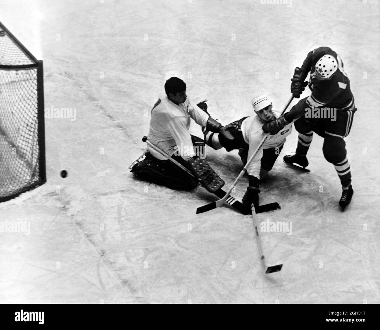 GIOCHI DELLE OLIMPIADI INVERNALI A INNSBRUCK, AUSTRIA - HOCKEY SU GHIACCIO IL GOALIE SVIZZERO SVENTOLERÀ L'ATTACCO RUSSO ; 3 FEBBRAIO 1964 Foto Stock