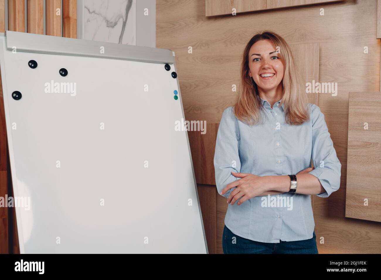 Donna d'affari giovane allenatore adulto in ufficio vuoto modello lavagna a fogli mobili lavagna bianca. Foto Stock