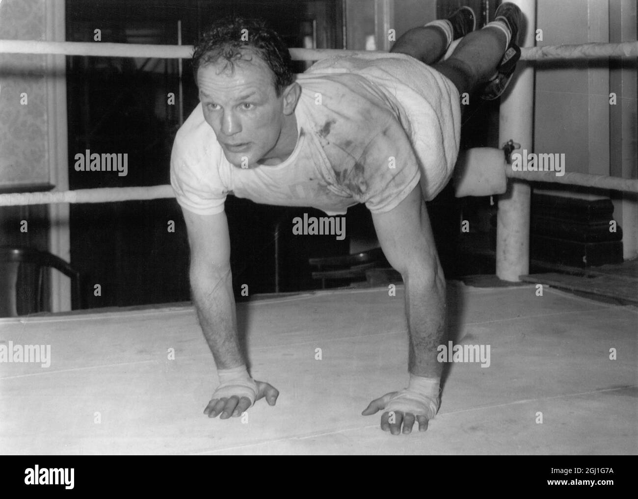 Henry Cooper fa pressione 's nel ring durante una sessione di allenamento al suo campo oggi . 11 febbraio 1964 Foto Stock