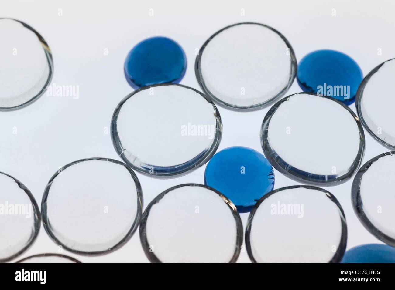 Ciottoli di vetro bianchi e blu con luce Foto Stock