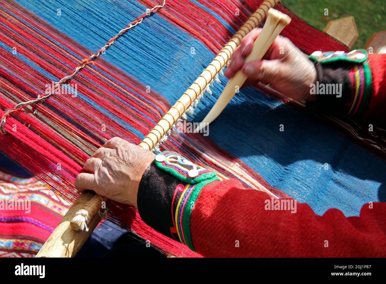 Sud America, Perù, Chinchero. Il tessitore cooperativo Chinchero dimostra l'utilizzo di un telaio e di uno strumento. Foto Stock
