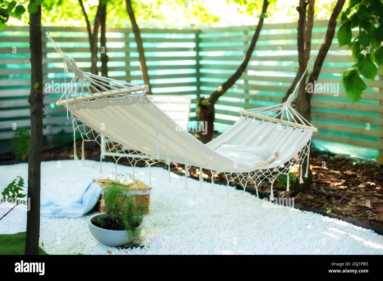 Comoda amaca appesa all'albero nel giardino estivo. Accogliente luogo ideale per il fine settimana di relax nel cortile. Foto Stock