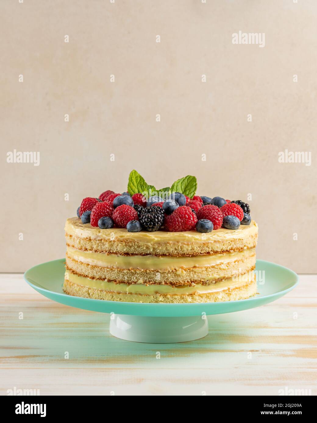 Torta fatta in casa con frutti di bosco freschi su sfondo di legno. Foto Stock