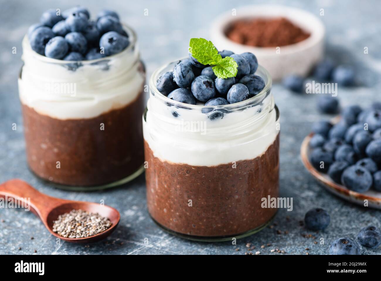 Budino Chia con yogurt e cioccolato con mirtilli freschi, vista Closeup. Dolce yogurt sano parfait Foto Stock