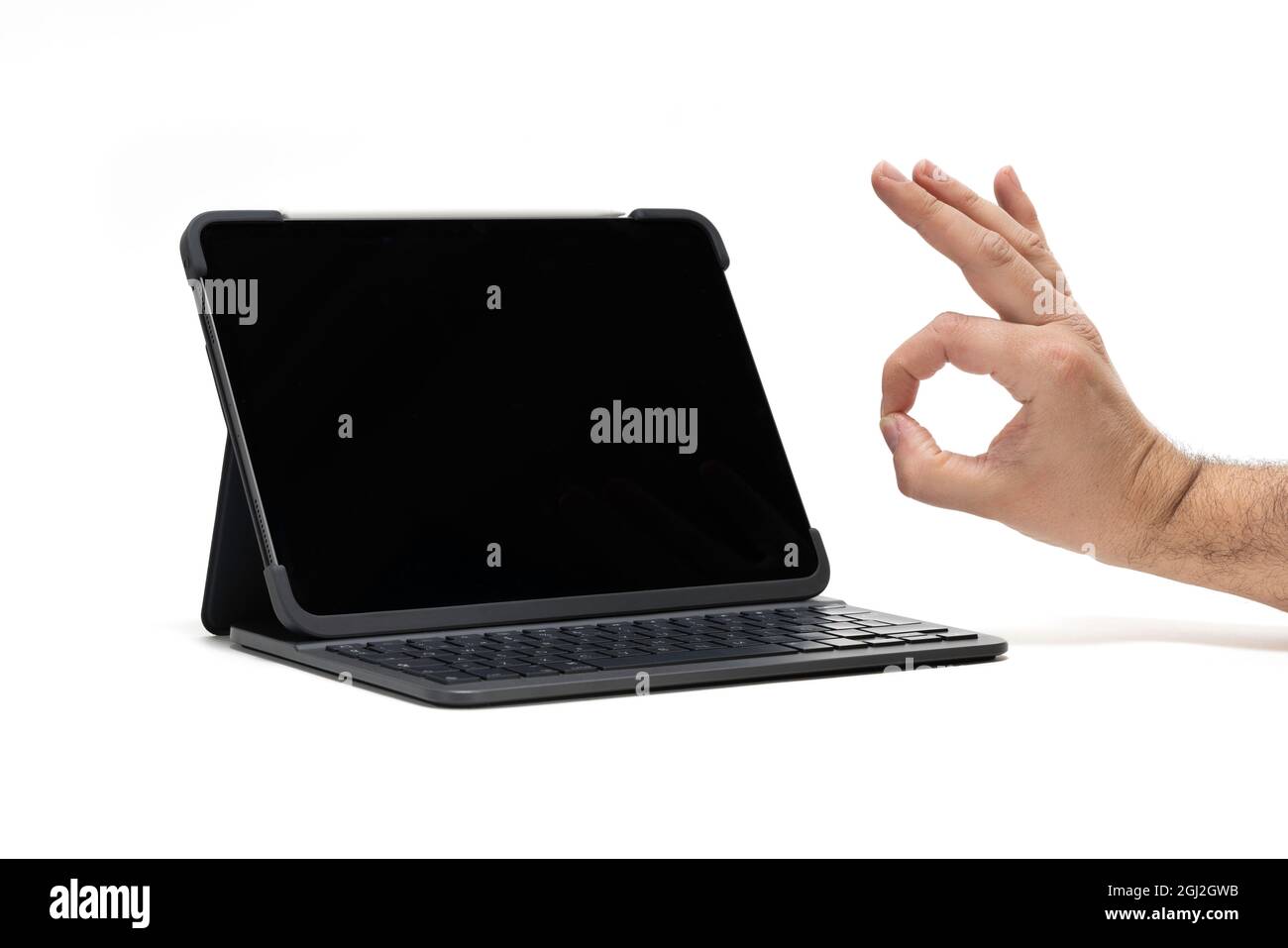 Un tablet con tastiera su sfondo bianco con approvazione a mano Foto Stock