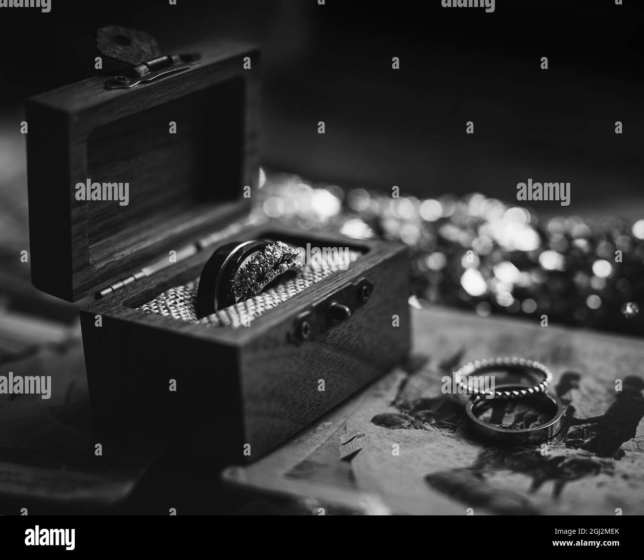 Scatto in scala di grigi degli anelli di aggancio in una scatola di legno Foto Stock