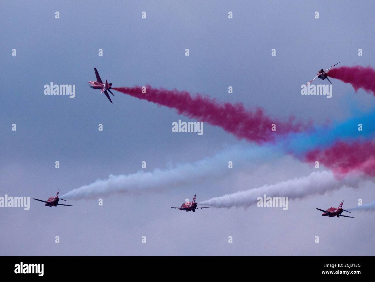 Due delle frecce rosse mostrano la squadra che vola lontano dall'area principale di esposizione per riformare, lasciando i percorsi di fumo. Foto Stock
