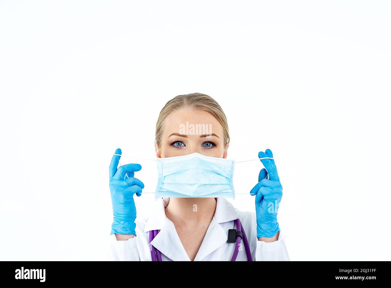Donna che indossa una maschera di protezione antivirus per prevenire altre infezioni da corona COVID-19 e SARS COV 2. La donna mette su un medico protettivo Foto Stock