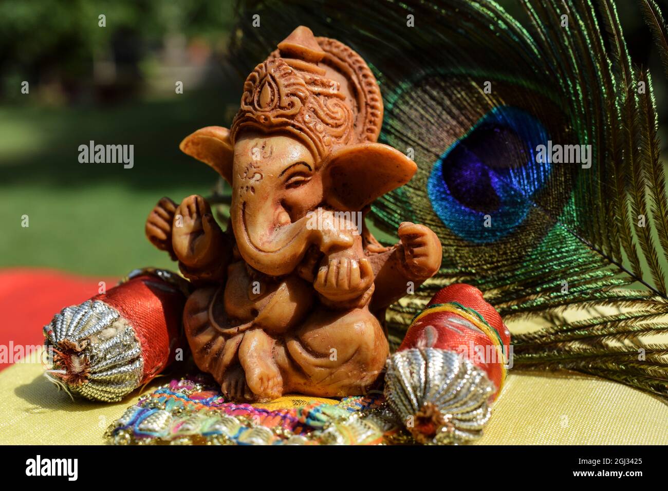 Bel signore Ganesha idol adorato durante il festival di Ganesh chaturthi con piume di pavone sullo sfondo. Foto Stock