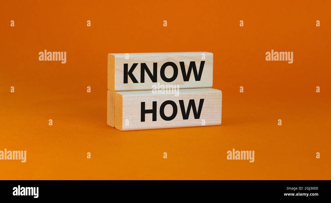 Sapere come simbolo. Concetto parole 'know how' su blocchi di legno su uno sfondo arancione bello. Business e know how concetto, spazio di copia. Foto Stock
