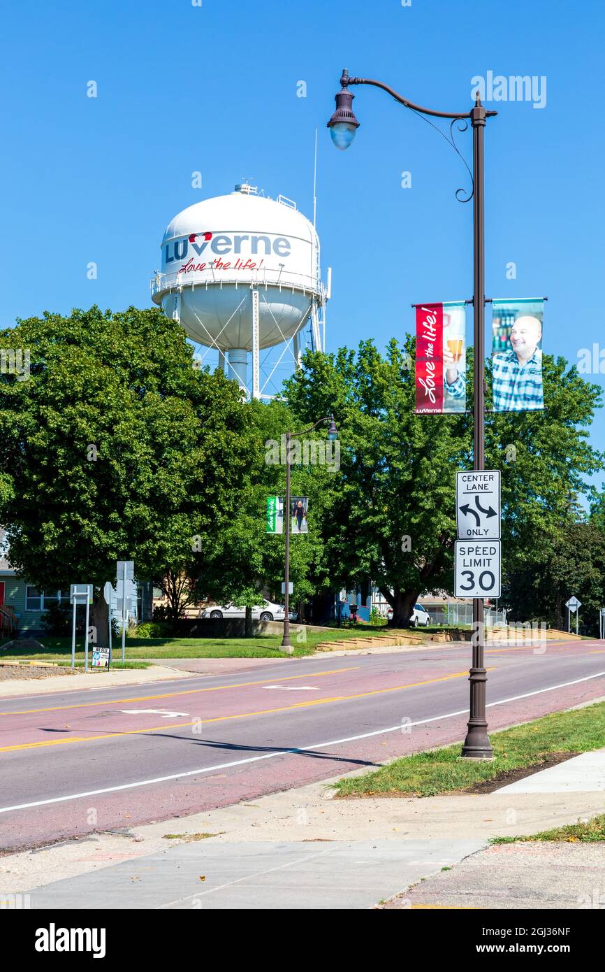 LUVERNE, MN, USA-21 AGOSTO 2021: La torre d'acqua Luverne e la luce di strada con una bandiera 'Love the Life'. Torre, segnaletica, semaforo. Foto Stock