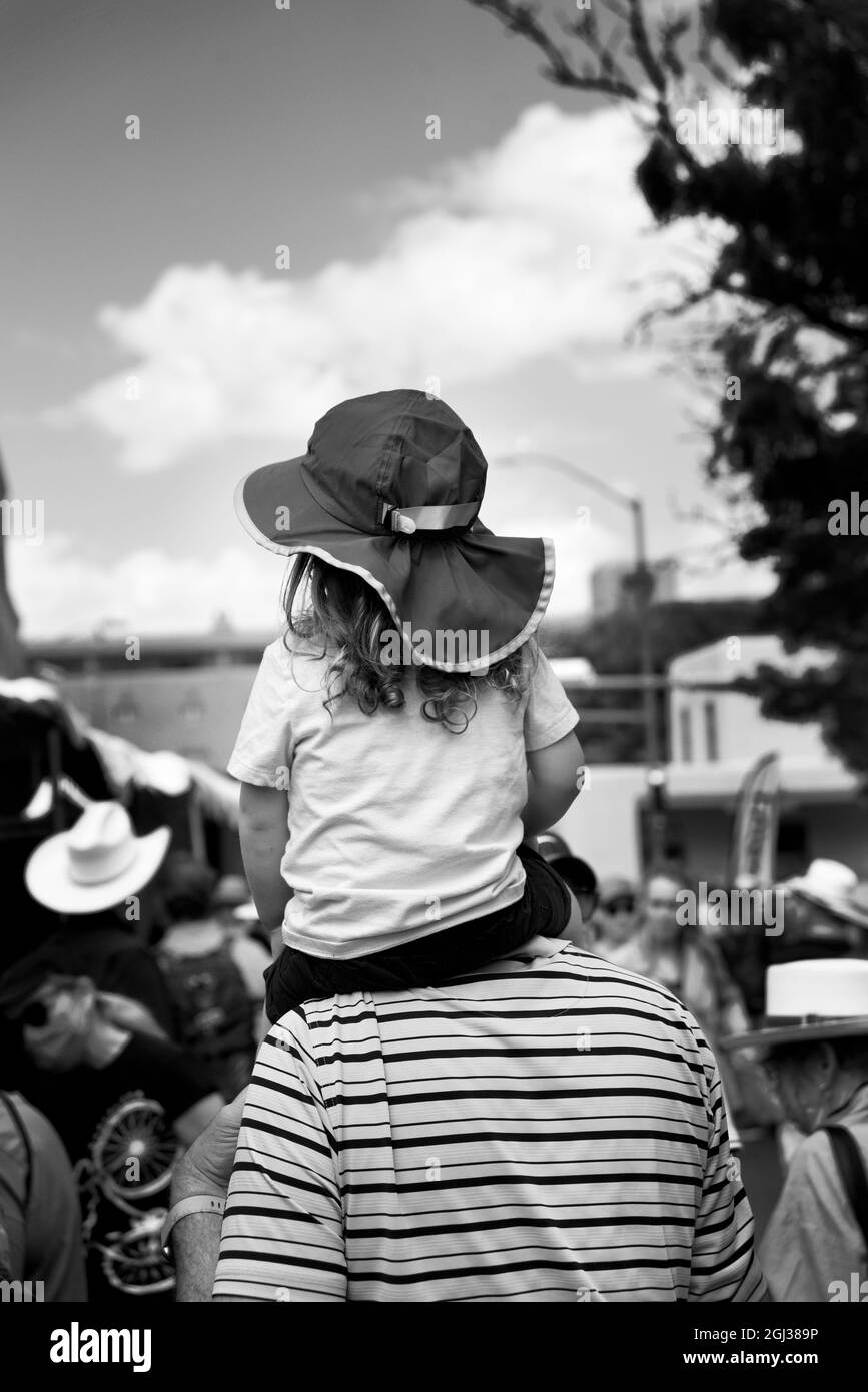 Un uomo porta sua figlia sulle spalle mentre si godono visitare un festival all'aperto di arte a Santa Fe, New Mexico. Foto Stock
