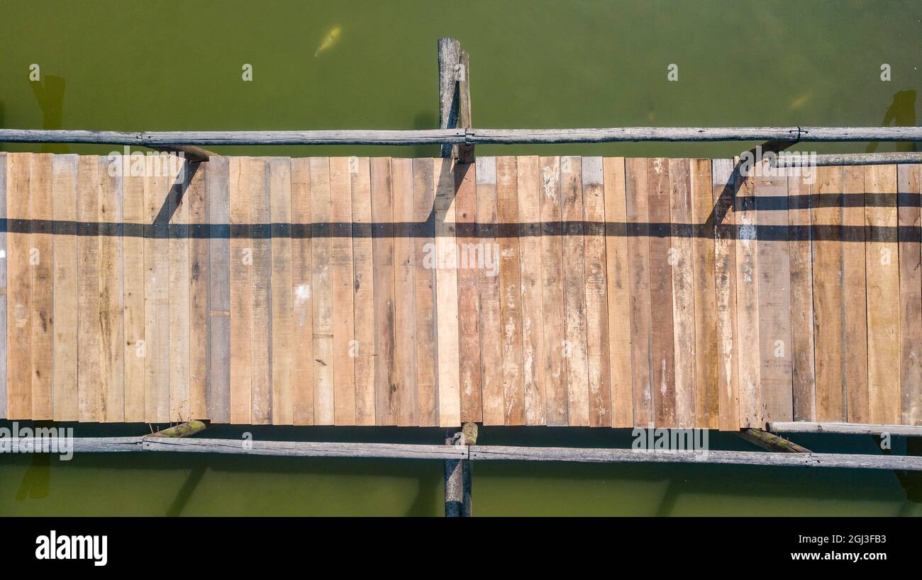 Ponte di legno, con corrimano, in un lago con acqua verdastra, a immagine di drone Foto Stock