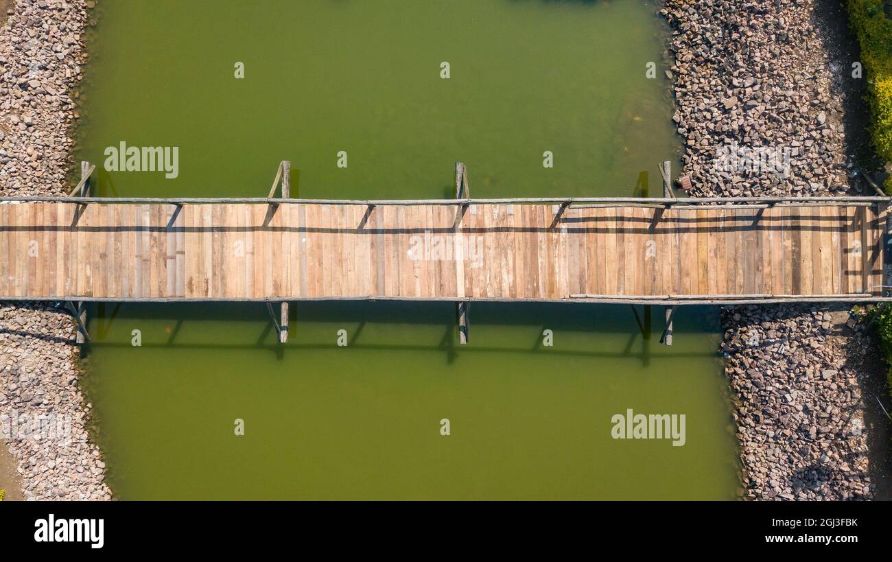 Ponte di legno, con corrimano, in un lago con acqua verdastra, a immagine di drone Foto Stock