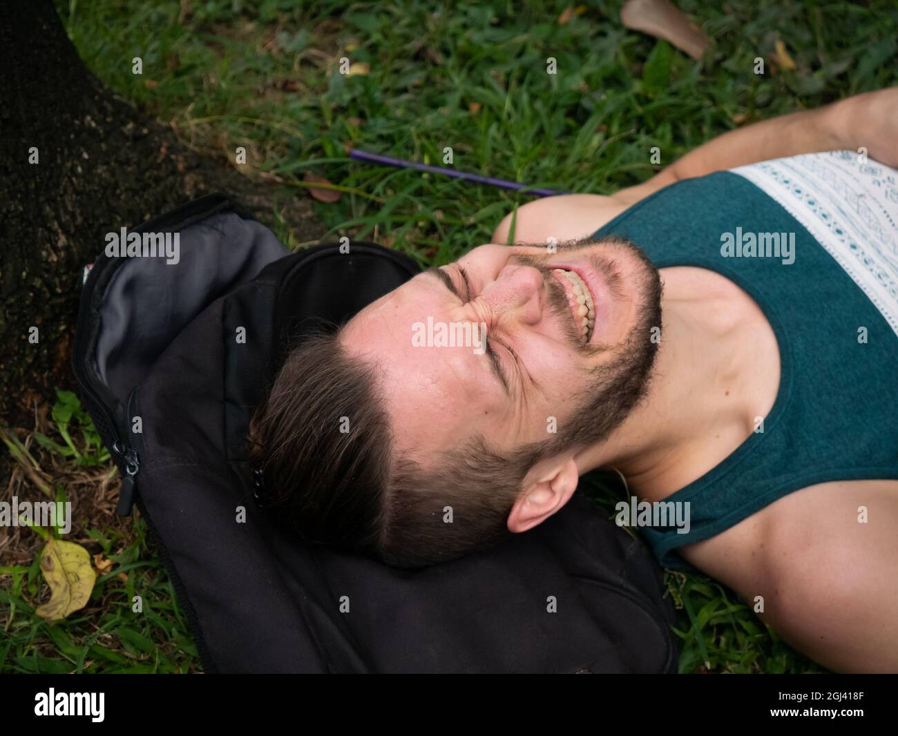 L'uomo bianco che giace sull'erba sente un lotto di dolore Foto Stock