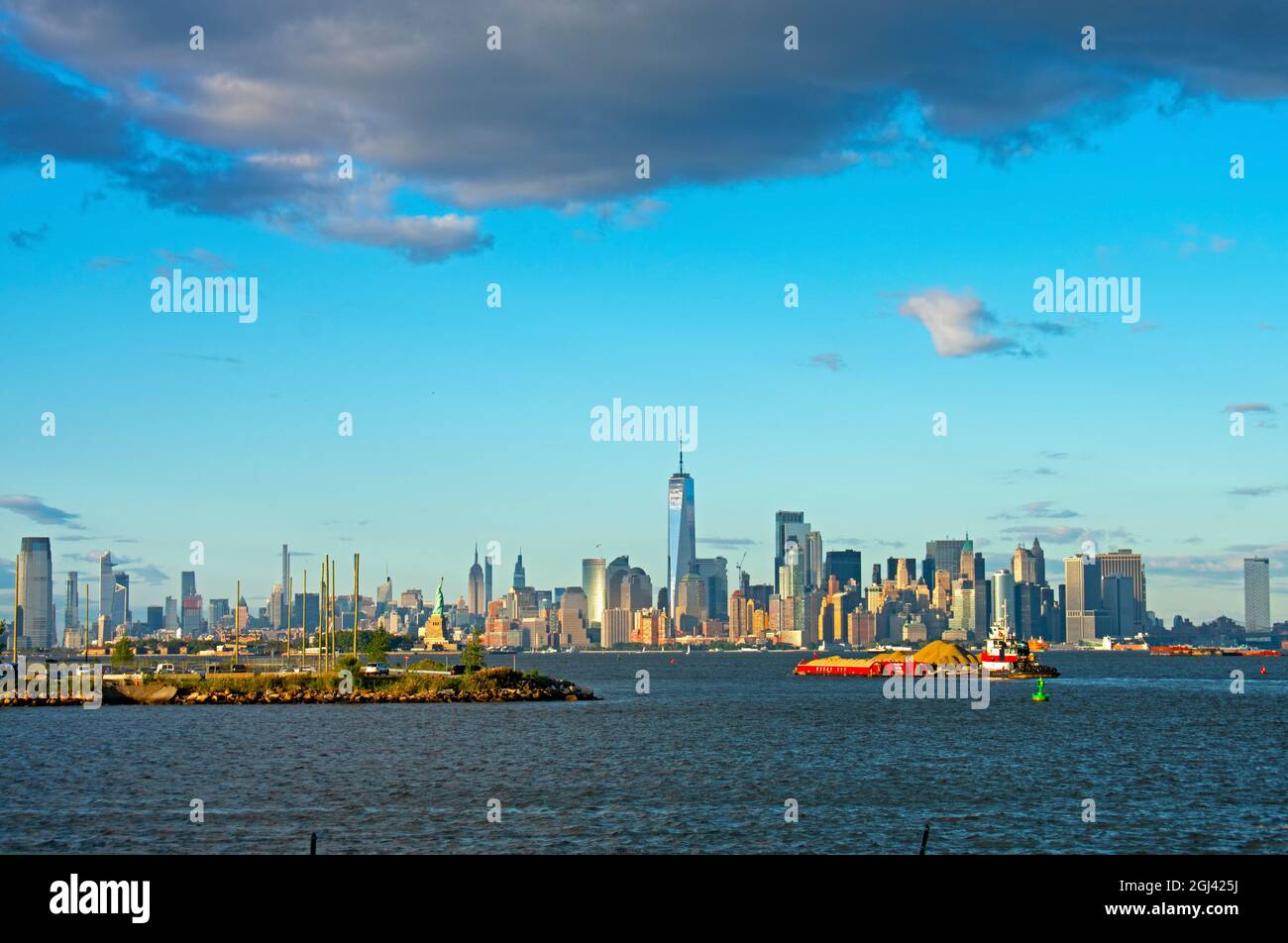 Vista dello skyline dell'isola di Manhattan di New York City, tra cui la Freedom Tower, l'Empire state Building e la Statua della libertà, in una giornata di sole -01 Foto Stock