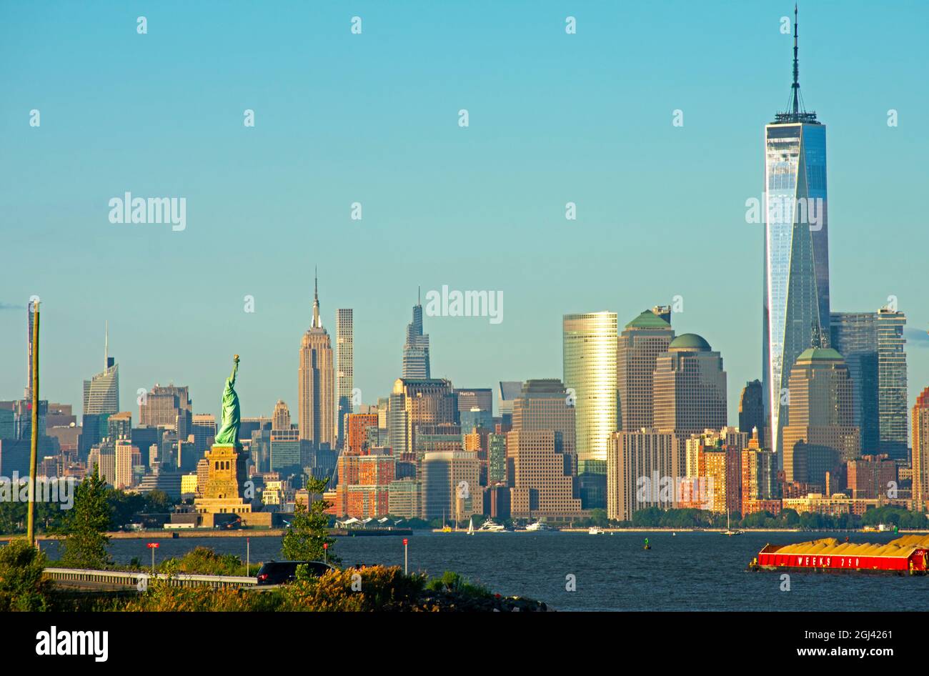 Vista dello skyline dell'isola di Manhattan di New York City, tra cui la Freedom Tower, l'Empire state Building e la Statua della libertà, in una giornata di sole -02 Foto Stock