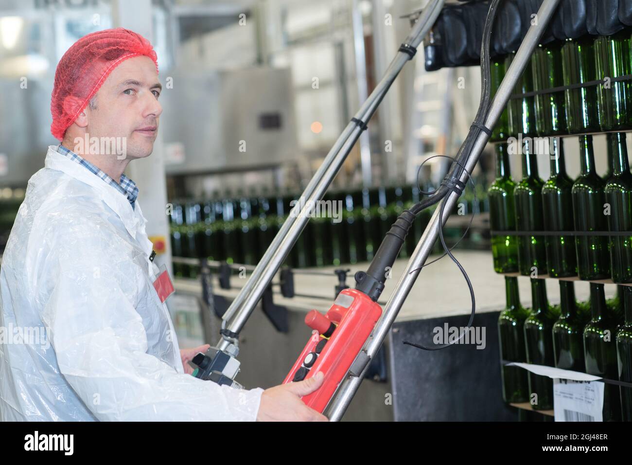 lavoratore che opera controlli in un impianto di imbottigliamento del vino Foto Stock